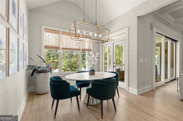 dining space featuring lofted ceiling, french doors, light hardwood / wood-style flooring, and a healthy amount of sunlight