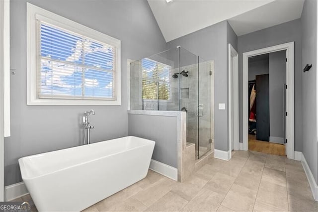 bathroom with tile patterned floors, vaulted ceiling, and plus walk in shower