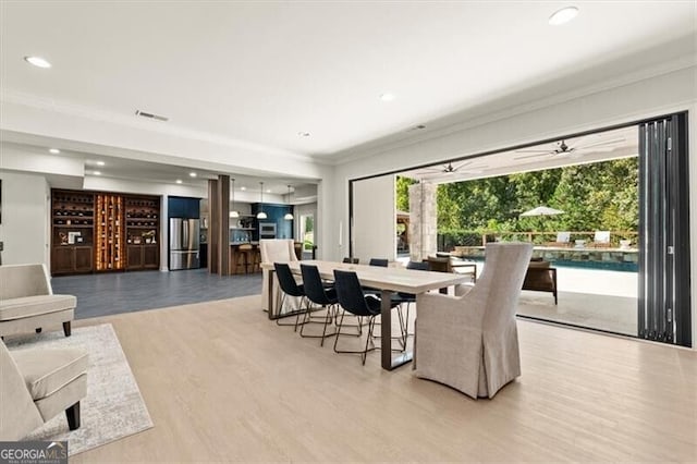 dining space featuring crown molding, ceiling fan, light wood-type flooring, and plenty of natural light