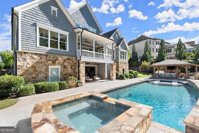 rear view of house with a pool with hot tub, outdoor lounge area, a gazebo, a patio, and ceiling fan