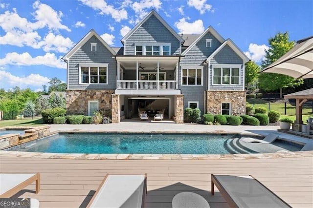 back of house with a pool side deck and ceiling fan