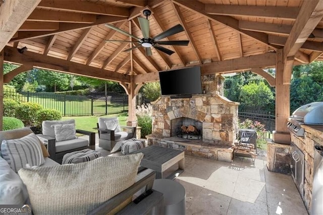 view of patio / terrace with a gazebo, exterior kitchen, ceiling fan, area for grilling, and an outdoor living space with a fireplace