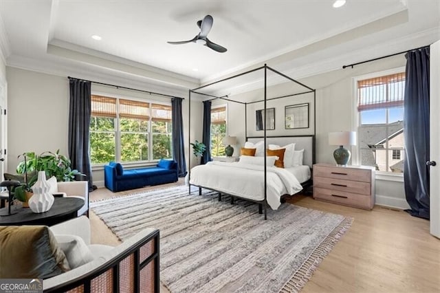 bedroom with multiple windows, crown molding, light wood-type flooring, and ceiling fan