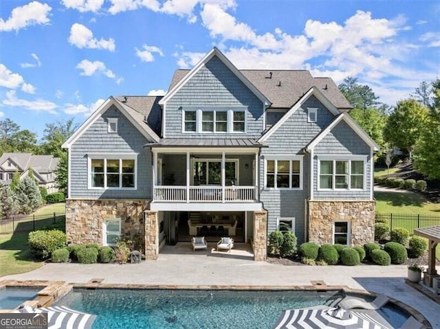 rear view of property featuring a patio and a fenced in pool