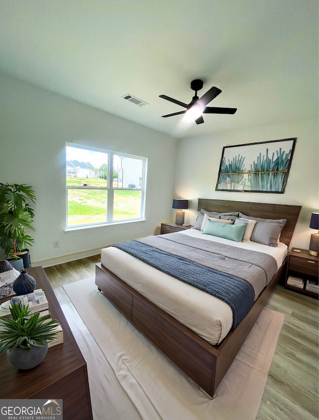 bedroom with light hardwood / wood-style floors and ceiling fan