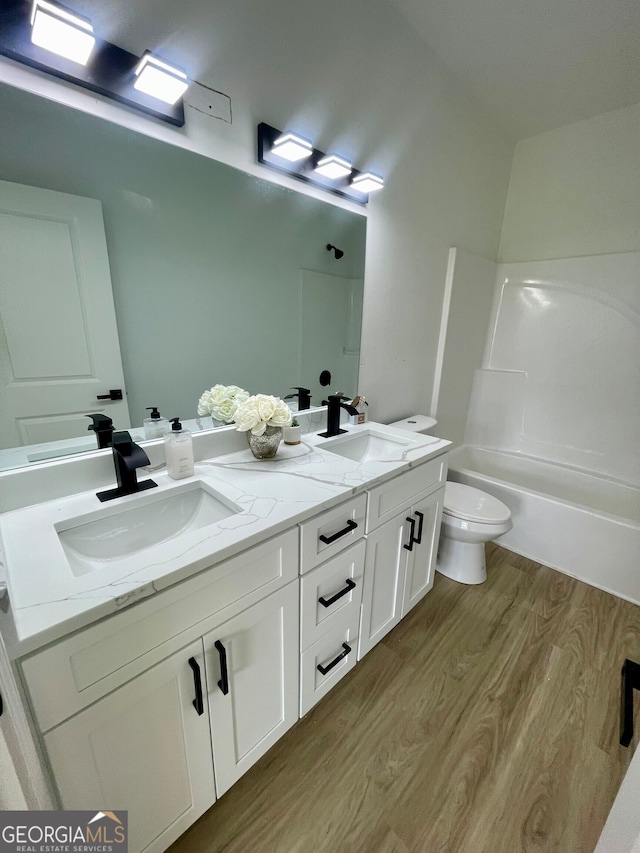 full bathroom featuring vanity, toilet, wood-type flooring, and shower / washtub combination