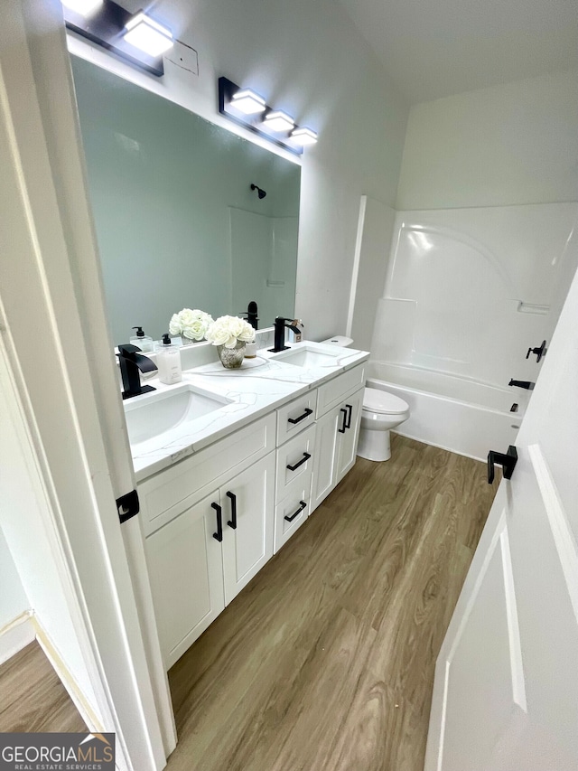 full bathroom with hardwood / wood-style flooring, vanity, toilet, and shower / bathing tub combination