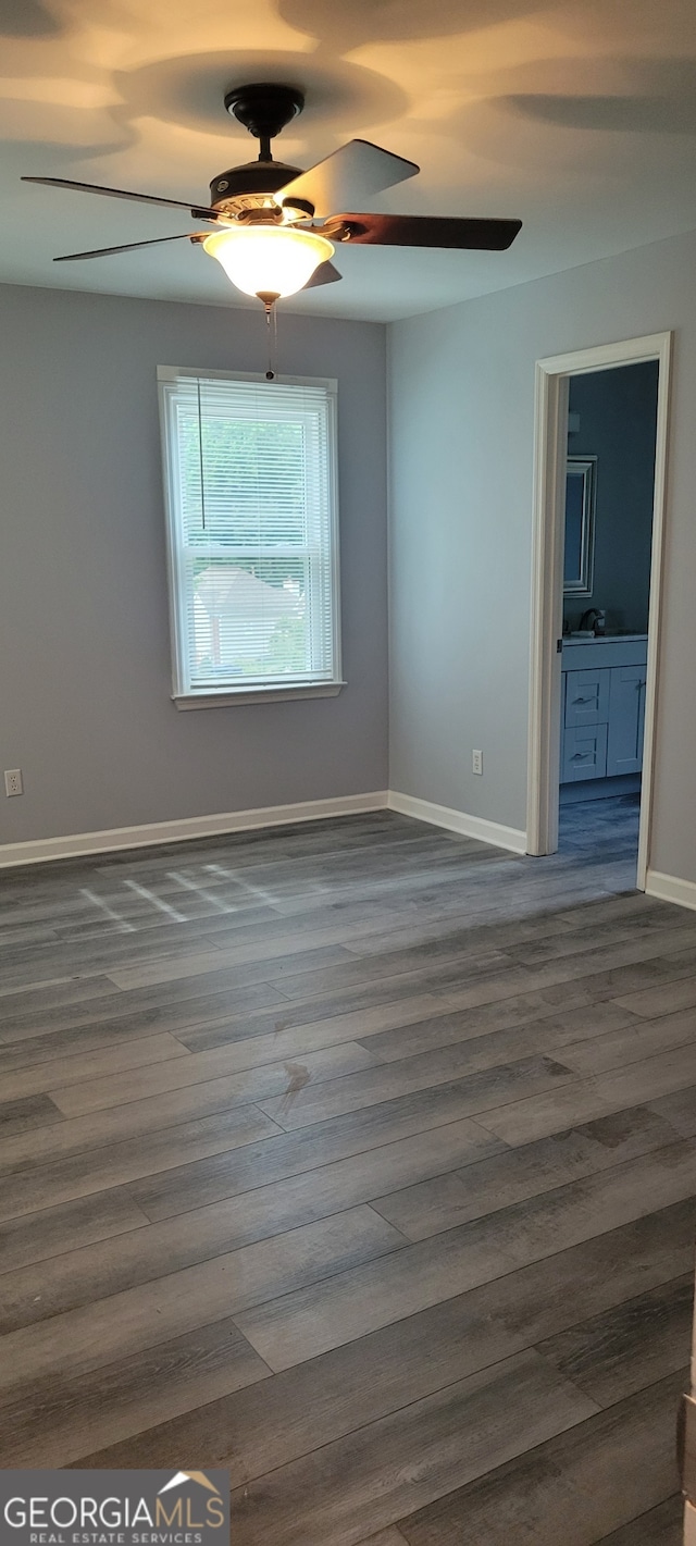 unfurnished room with dark wood-type flooring and ceiling fan