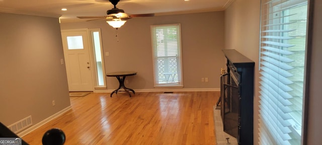 entrance foyer with crown molding, light hardwood / wood-style flooring, and ceiling fan