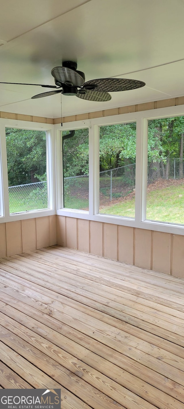 unfurnished sunroom with ceiling fan