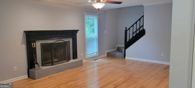 living room with ornamental molding, hardwood / wood-style floors, a fireplace, and ceiling fan