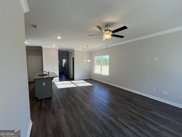 unfurnished living room featuring crown molding, ceiling fan with notable chandelier, dark hardwood / wood-style floors, and sink