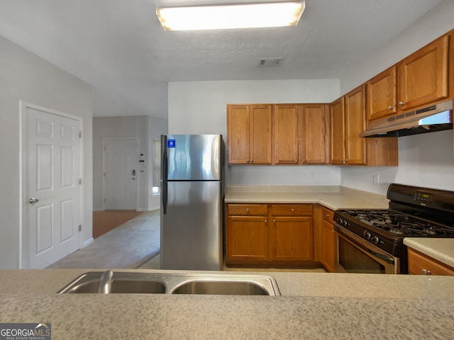 kitchen featuring stainless steel fridge, a textured ceiling, and black gas range oven