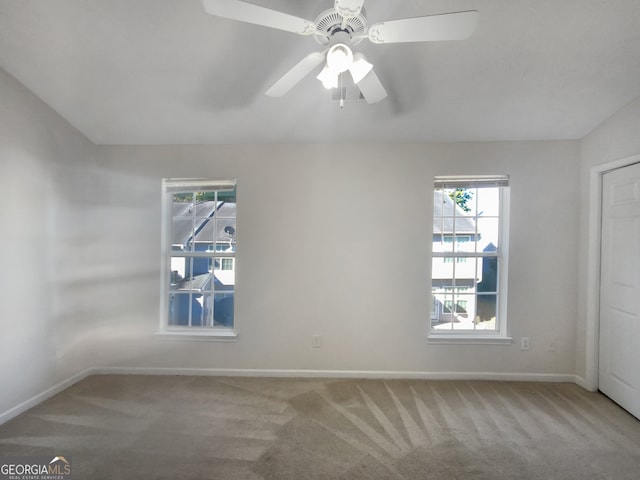 unfurnished room with light colored carpet and ceiling fan