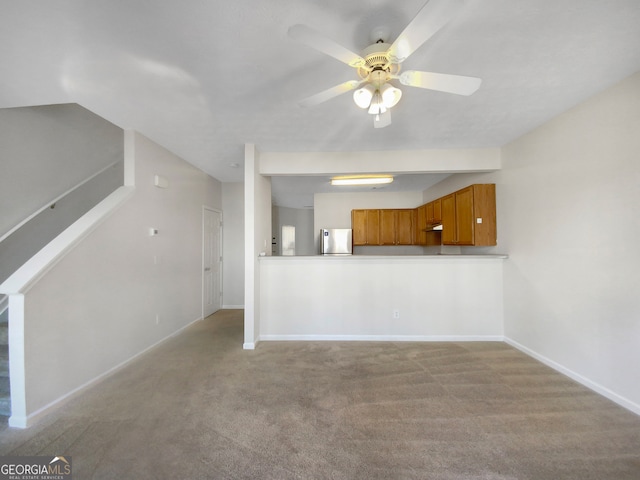 unfurnished living room featuring light colored carpet and ceiling fan