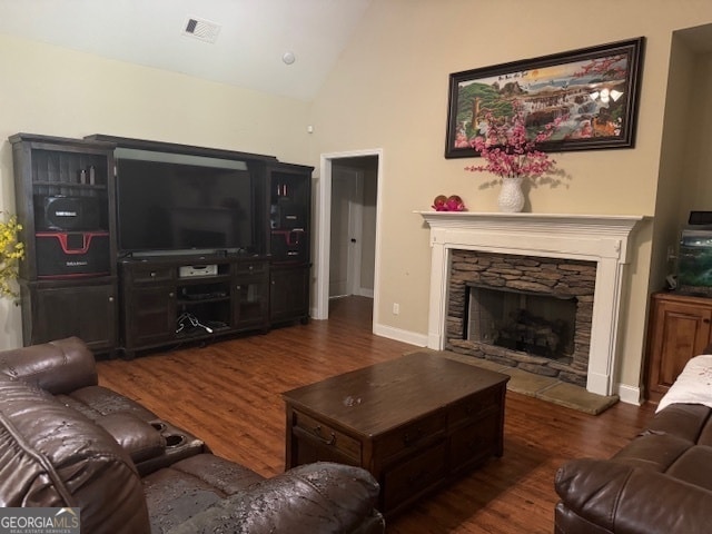 living room featuring a stone fireplace, dark hardwood / wood-style floors, and high vaulted ceiling