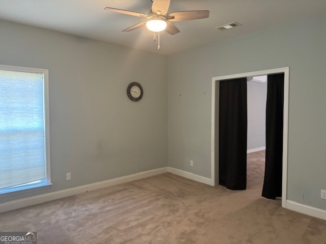 carpeted spare room featuring ceiling fan