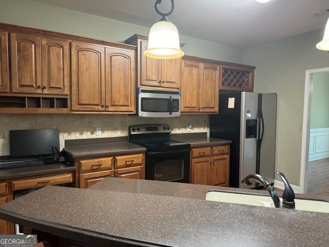 kitchen with tasteful backsplash, sink, stainless steel appliances, decorative light fixtures, and hardwood / wood-style flooring