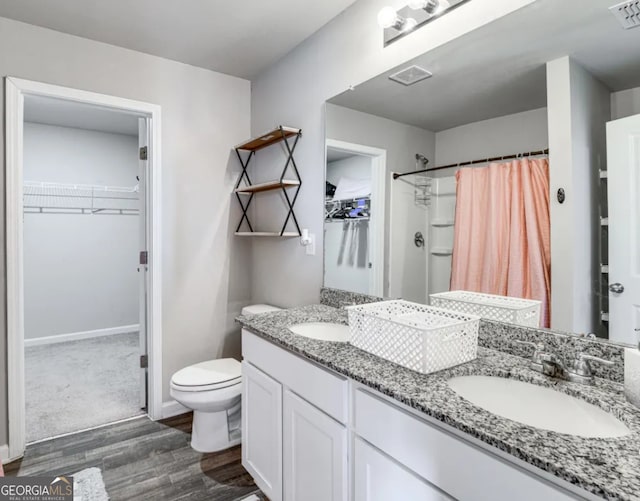 bathroom featuring vanity, hardwood / wood-style floors, a shower with curtain, and toilet