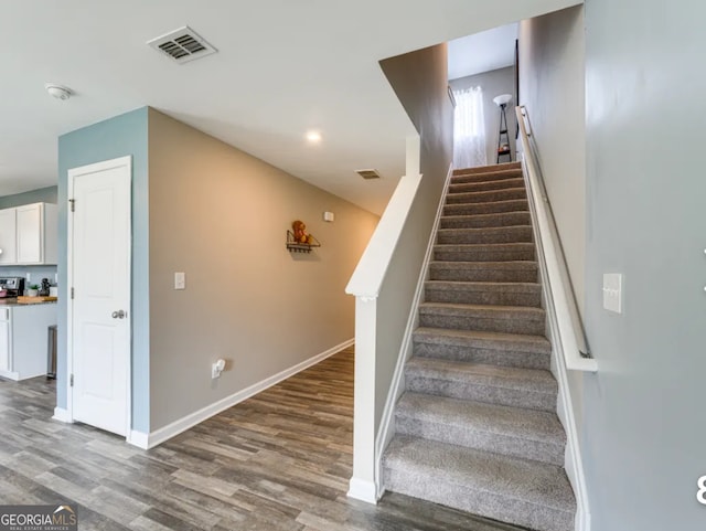 staircase with hardwood / wood-style floors