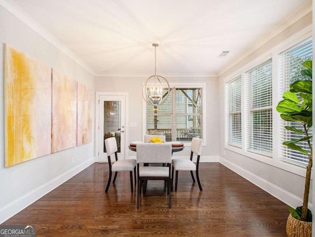 dining room with an inviting chandelier, ornamental molding, and dark hardwood / wood-style flooring