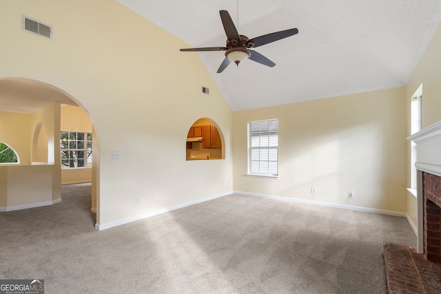 unfurnished living room with light colored carpet, high vaulted ceiling, and a brick fireplace