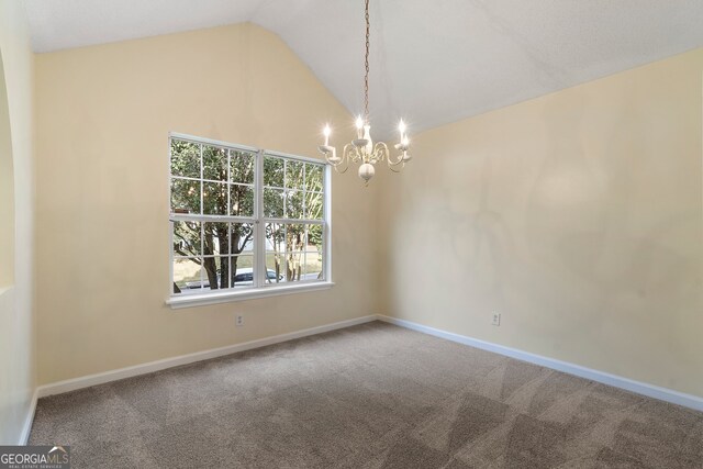 carpeted empty room with a notable chandelier and high vaulted ceiling