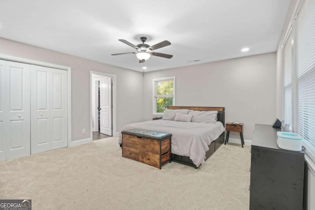 carpeted bedroom featuring a closet and ceiling fan