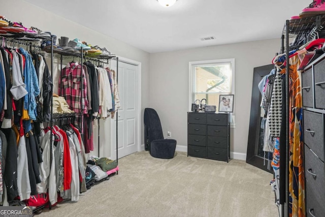 spacious closet featuring light colored carpet