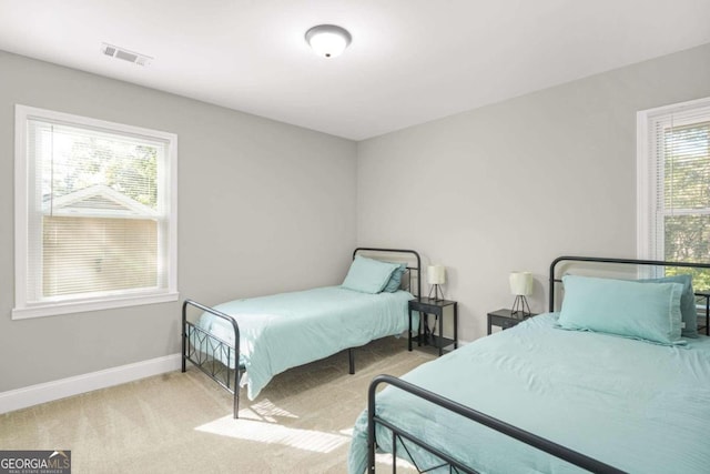 carpeted bedroom featuring multiple windows