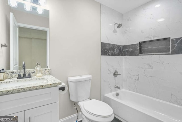 full bathroom featuring tiled shower / bath, vanity, and toilet