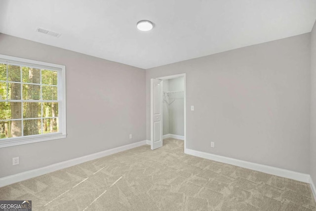 unfurnished bedroom featuring light colored carpet and a closet