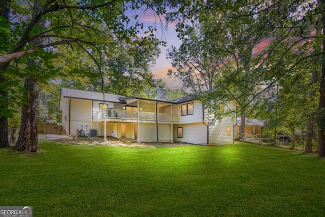 back house at dusk featuring a yard