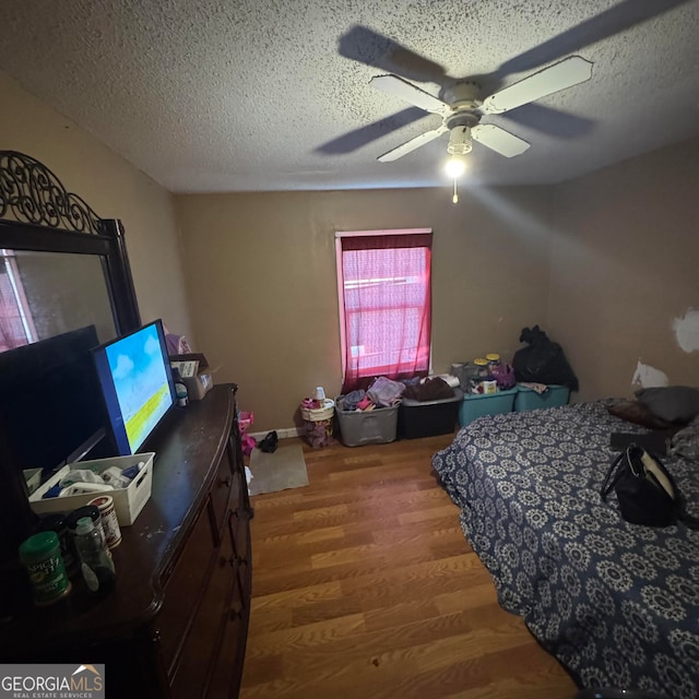 bedroom featuring a textured ceiling, hardwood / wood-style flooring, and ceiling fan