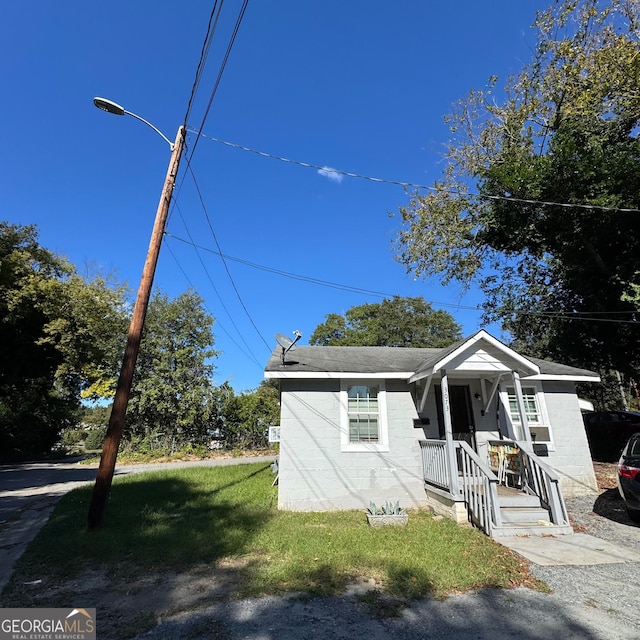 bungalow-style house featuring covered porch and a front lawn