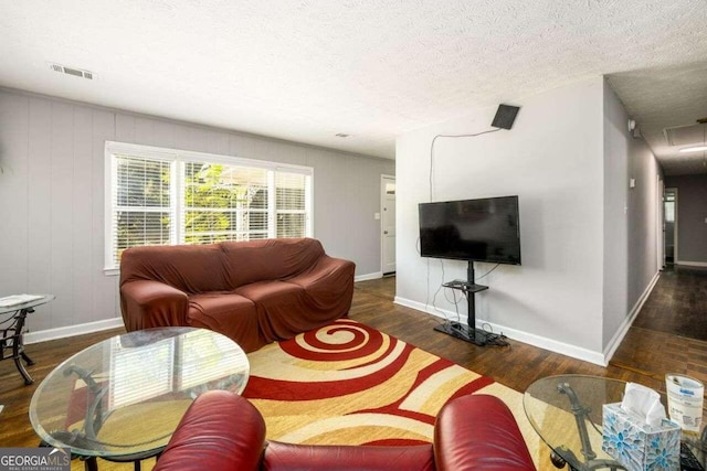 living room featuring dark wood-type flooring and a textured ceiling