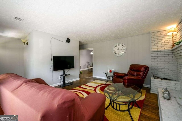 living room with a textured ceiling and dark hardwood / wood-style flooring