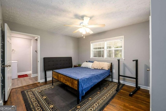 bedroom with a textured ceiling, dark wood-type flooring, and ceiling fan