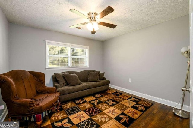 sitting room featuring dark hardwood / wood-style floors, a textured ceiling, and ceiling fan