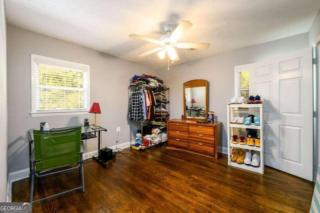 miscellaneous room featuring dark wood-type flooring, ceiling fan, and a textured ceiling