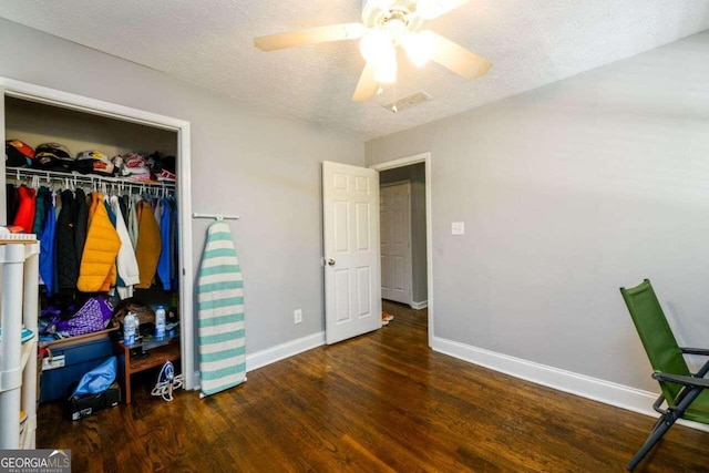 bedroom featuring a closet, ceiling fan, a textured ceiling, and dark hardwood / wood-style floors