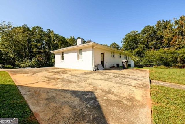 view of side of home with a yard and a patio