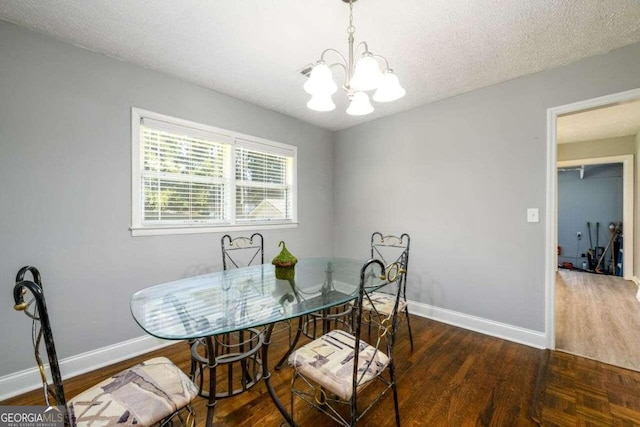 dining space featuring a textured ceiling, a notable chandelier, and dark hardwood / wood-style floors