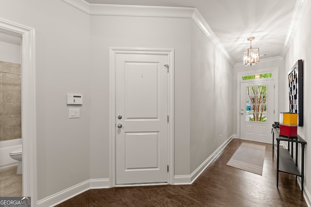 entryway with ornamental molding, dark hardwood / wood-style floors, and an inviting chandelier