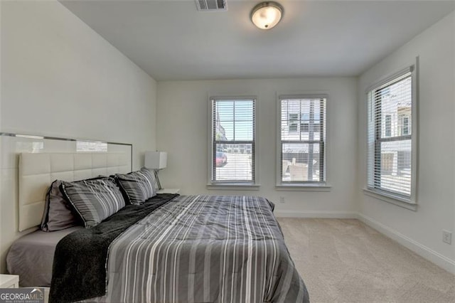 carpeted bedroom featuring multiple windows