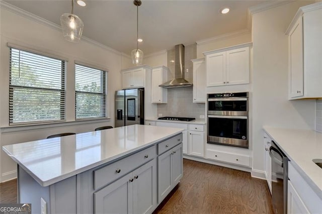 kitchen with white cabinetry, wall chimney range hood, and stainless steel appliances