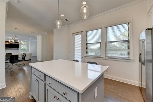 kitchen with gray cabinets, ornamental molding, hanging light fixtures, and high quality fridge