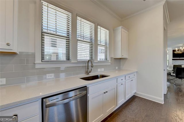 kitchen with backsplash, white cabinets, sink, stainless steel dishwasher, and ornamental molding