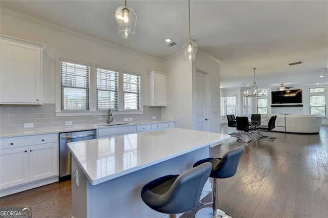 kitchen featuring dishwasher, white cabinetry, a kitchen island, and sink