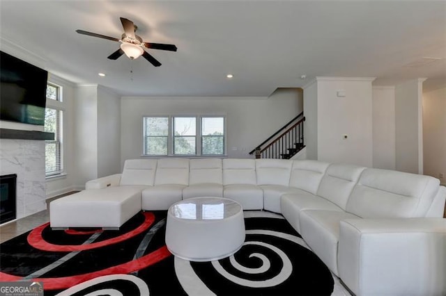 living room featuring a premium fireplace and ceiling fan